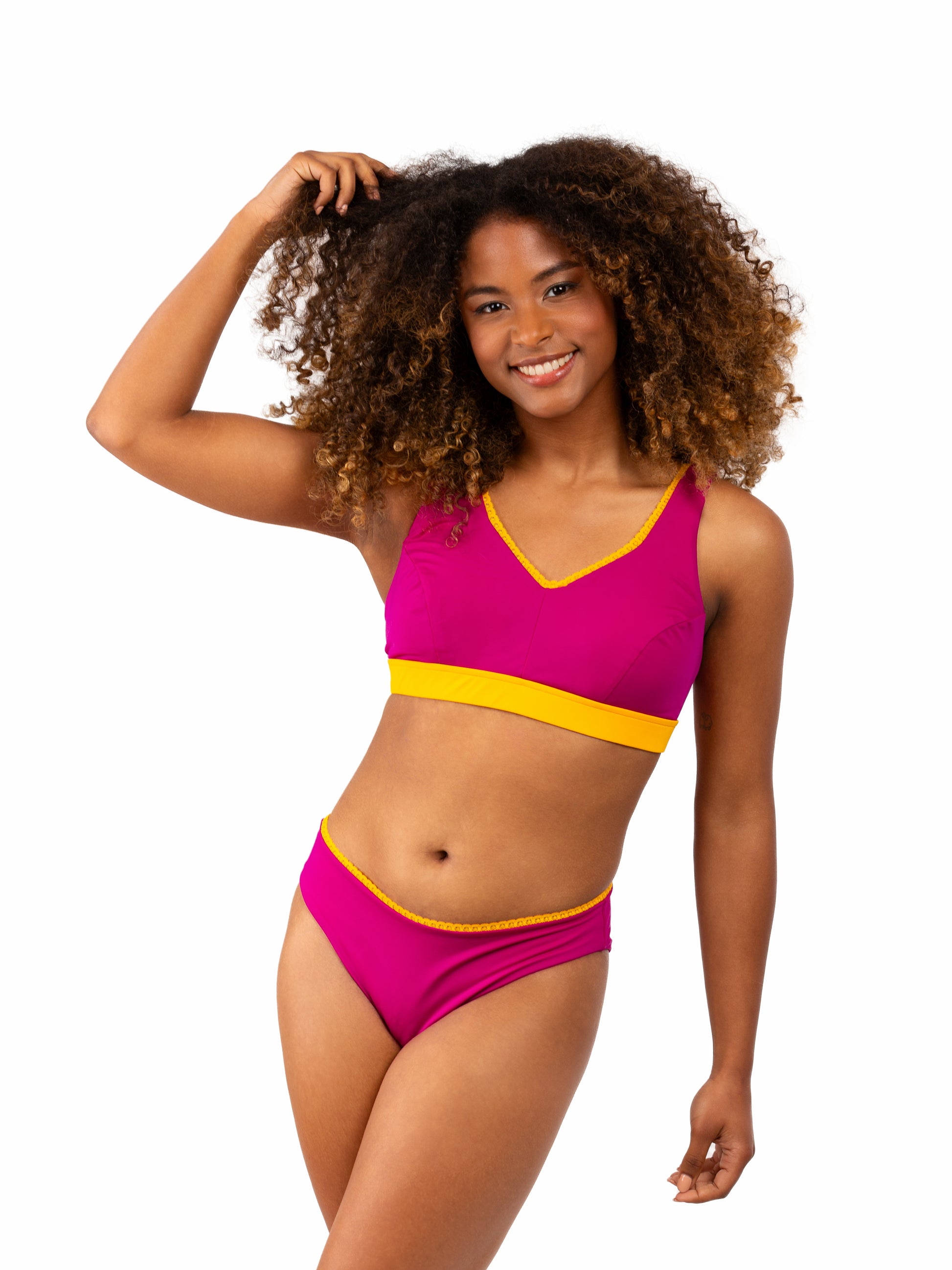 Prothese bikini in een roze kleur met meer bedekking van het decollete. De bikini heeft ook speels gele ruches. 